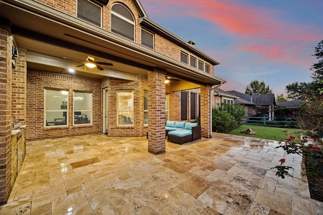 patio terrace at dusk with outdoor lounge area and ceiling fan