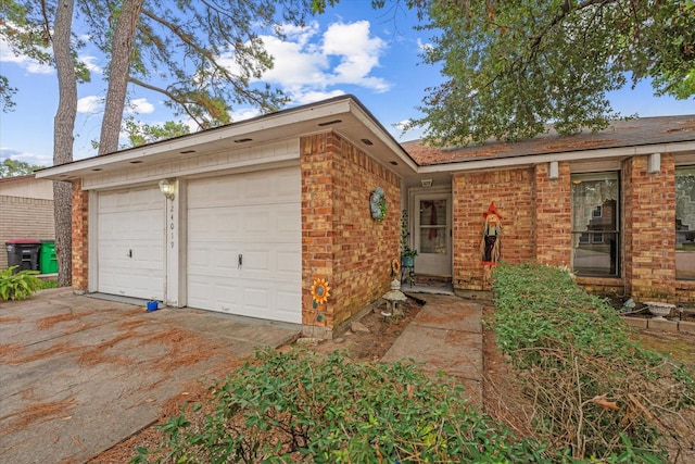 single story home featuring brick siding, an attached garage, and concrete driveway