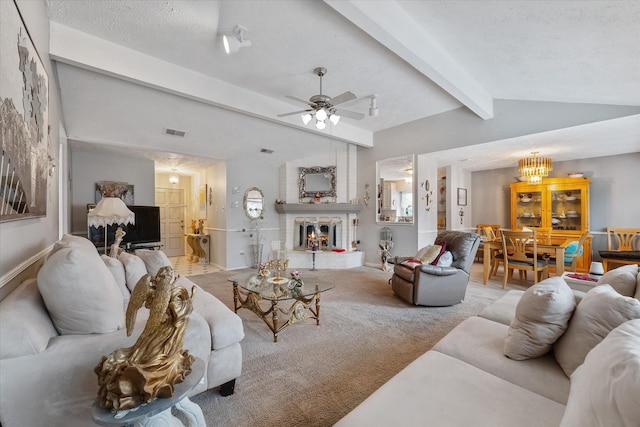 living room with visible vents, a textured ceiling, carpet flooring, a brick fireplace, and vaulted ceiling with beams