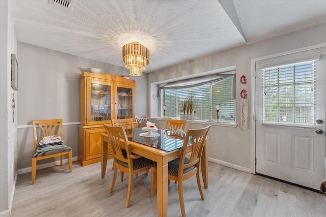 dining room featuring visible vents, a notable chandelier, light wood-style floors, and baseboards