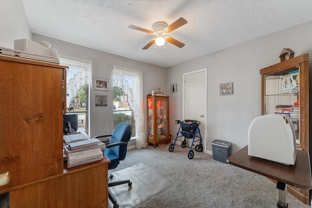 office area with baseboards, a ceiling fan, carpet flooring, and a textured ceiling