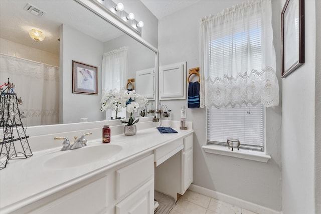 bathroom featuring vanity, tile patterned floors, baseboards, and visible vents