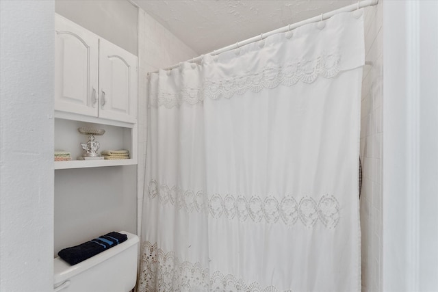 bathroom featuring curtained shower and toilet