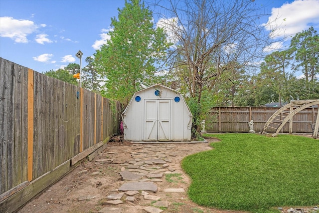 view of yard featuring an outbuilding, a storage shed, and a fenced backyard