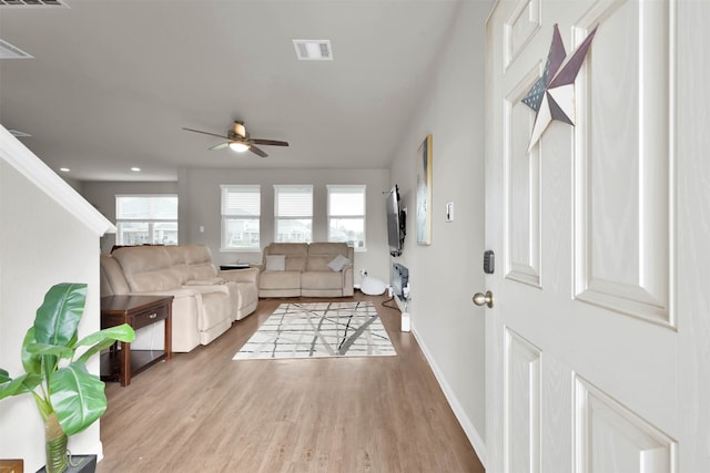 living room with ceiling fan and light wood-type flooring