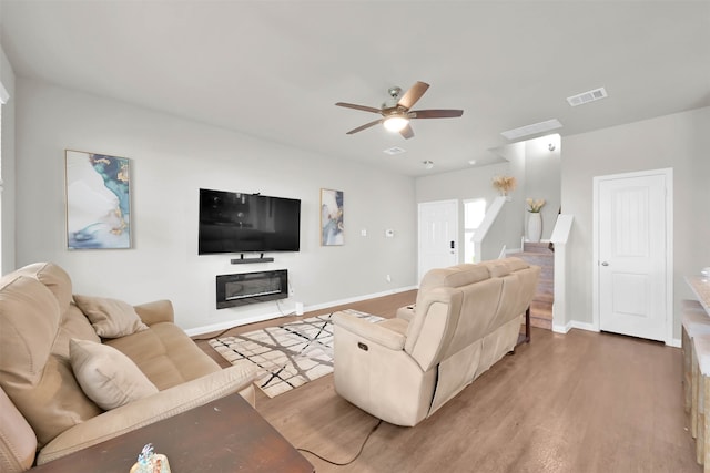 living room featuring hardwood / wood-style floors and ceiling fan