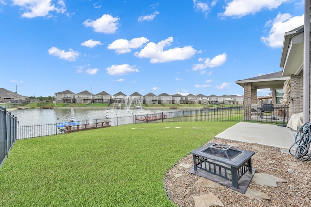 view of yard featuring a water view, an outdoor fire pit, and a patio