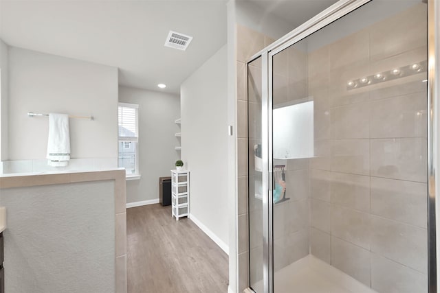 bathroom with an enclosed shower and wood-type flooring