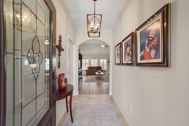 hall with light hardwood / wood-style floors and an inviting chandelier