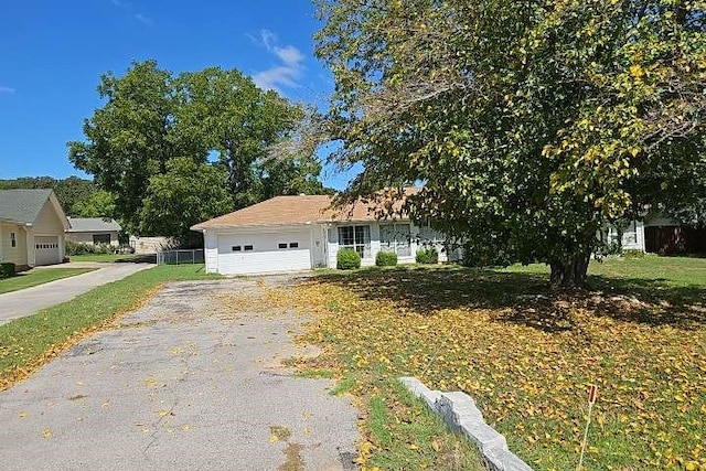 ranch-style home with a garage and a front lawn