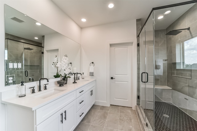 bathroom featuring a shower with shower door and vanity