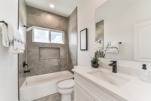 full bathroom with toilet, tiled shower / bath combo, vanity, and tile patterned floors