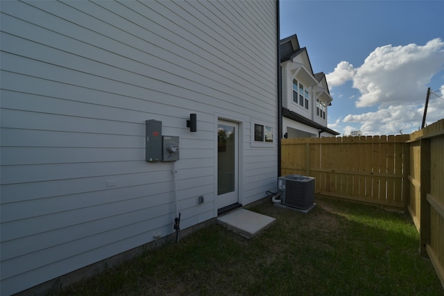 view of home's exterior with central AC unit and a yard