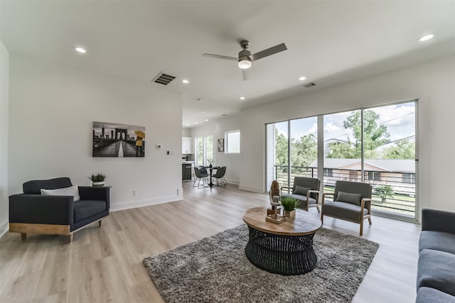 living room featuring light hardwood / wood-style flooring and ceiling fan