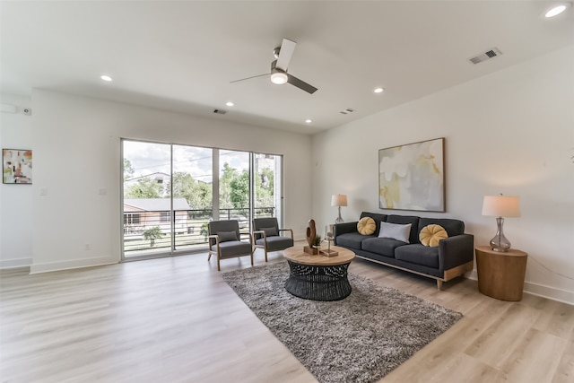 living room with ceiling fan and light hardwood / wood-style flooring