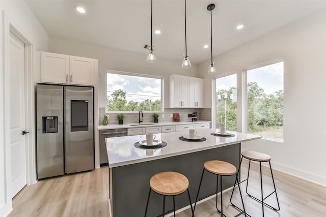 kitchen with plenty of natural light, appliances with stainless steel finishes, sink, and white cabinets