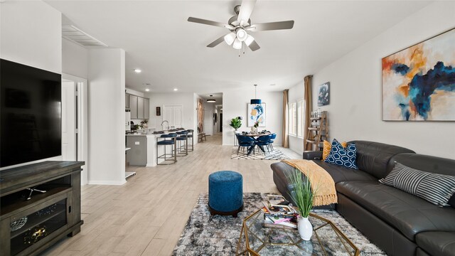 living room with ceiling fan and light hardwood / wood-style floors