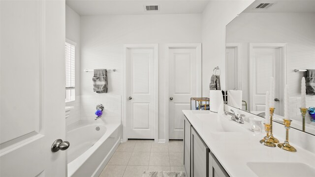 bathroom featuring a washtub, vanity, and tile patterned floors