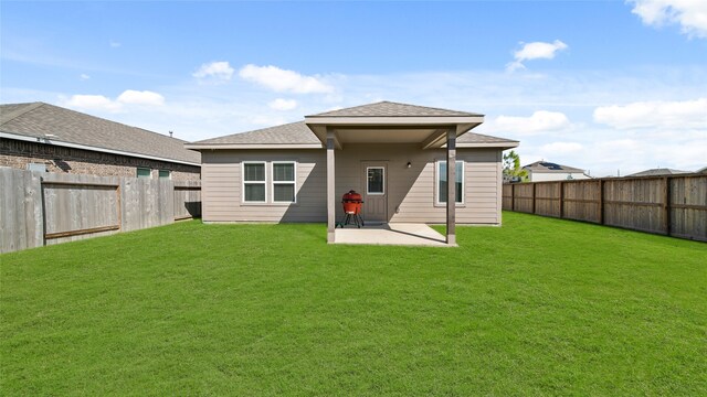 back of house featuring a patio and a yard