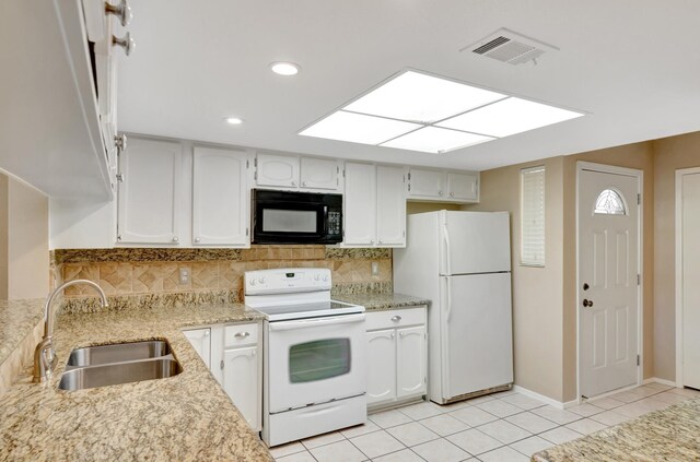 kitchen featuring white appliances, backsplash, sink, light tile patterned flooring, and white cabinetry