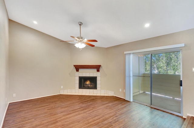 unfurnished living room featuring wood finished floors, a ceiling fan, baseboards, recessed lighting, and a tile fireplace