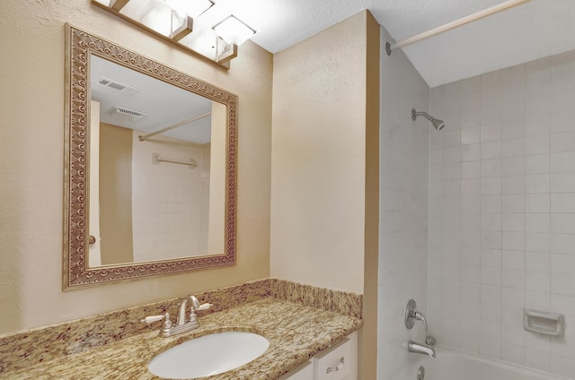 bathroom with vanity and tiled shower / bath combo