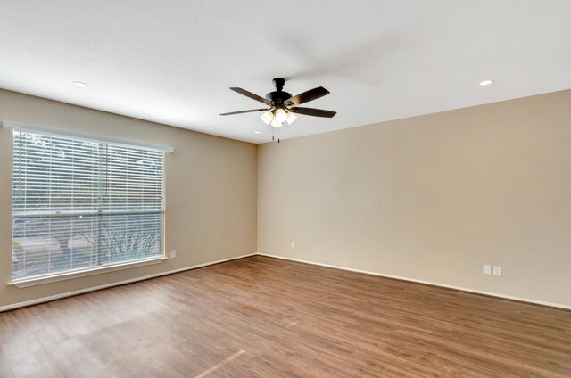 spare room featuring hardwood / wood-style flooring, plenty of natural light, and ceiling fan