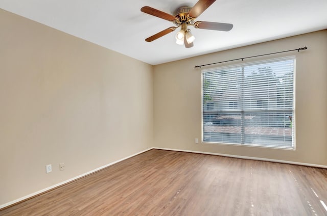 spare room with ceiling fan and light wood-type flooring