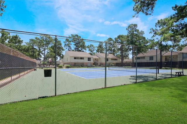 view of sport court with a lawn