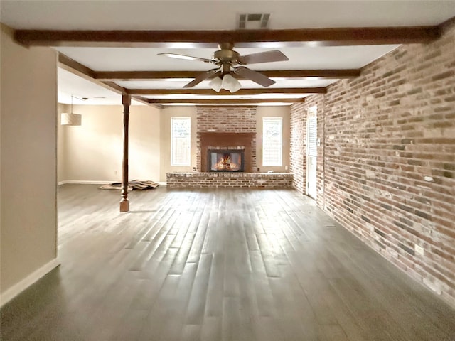 unfurnished living room featuring beamed ceiling, wood-type flooring, and brick wall