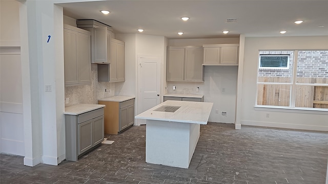 kitchen featuring gray cabinets, a center island, and backsplash