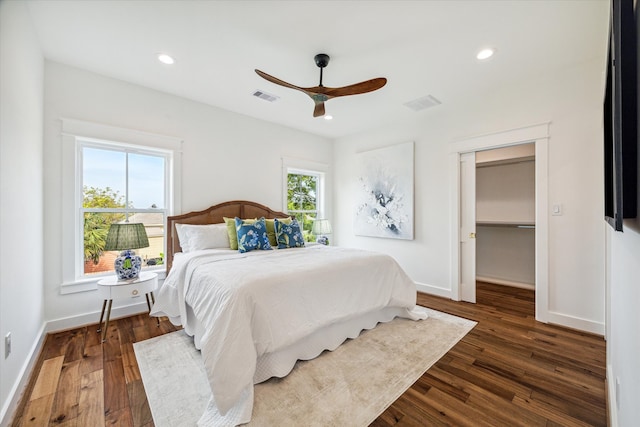 bedroom featuring dark wood-type flooring, multiple windows, and ceiling fan