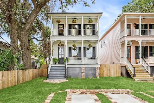 view of front of home featuring a porch, a front yard, ceiling fan, and a balcony