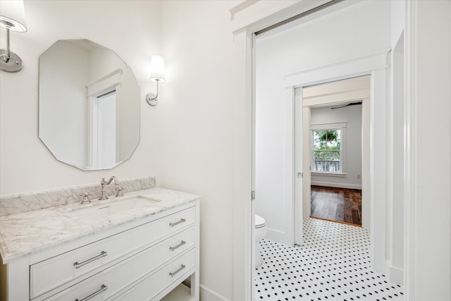 bathroom with toilet, vanity, and hardwood / wood-style flooring