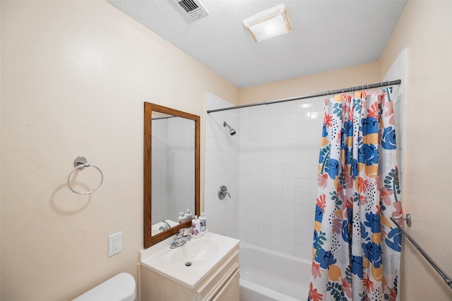 full bathroom with shower / bath combo, vanity, a textured ceiling, and toilet