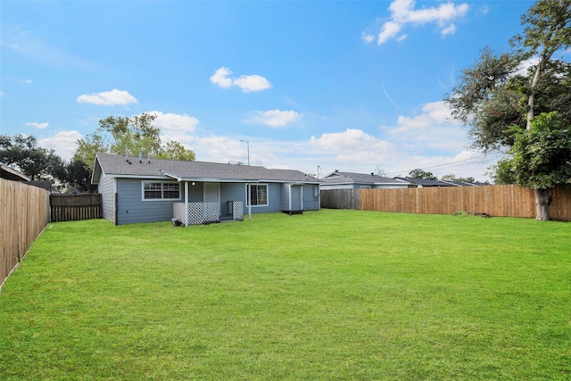 rear view of property featuring a lawn