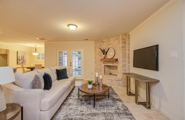 living room featuring a stone fireplace, french doors, and crown molding