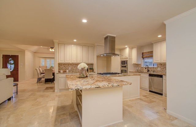 kitchen featuring stainless steel appliances, sink, white cabinets, wall chimney exhaust hood, and a center island