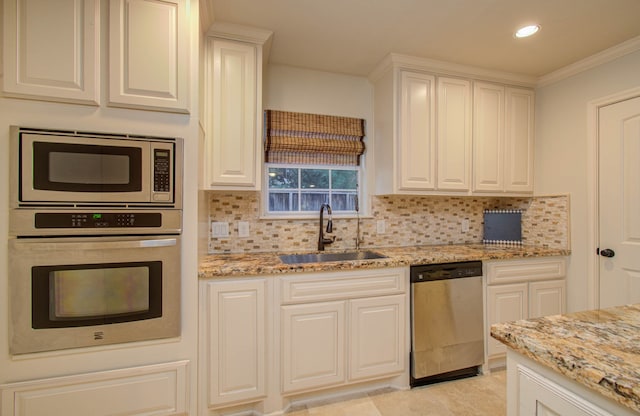 kitchen with white cabinets, sink, tasteful backsplash, crown molding, and appliances with stainless steel finishes