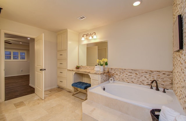 bathroom featuring vanity and tiled tub