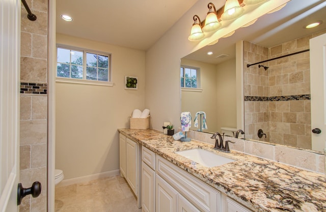 bathroom featuring tile patterned flooring, plenty of natural light, vanity, and toilet