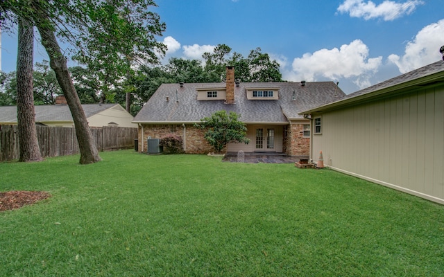 back of property featuring a lawn, central AC, french doors, and a patio area