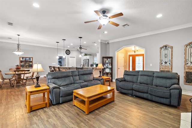 living room featuring a textured ceiling, wood-type flooring, ceiling fan, and crown molding