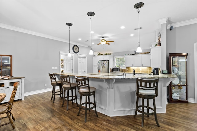 kitchen featuring decorative light fixtures, dark hardwood / wood-style floors, stainless steel refrigerator with ice dispenser, white cabinets, and kitchen peninsula