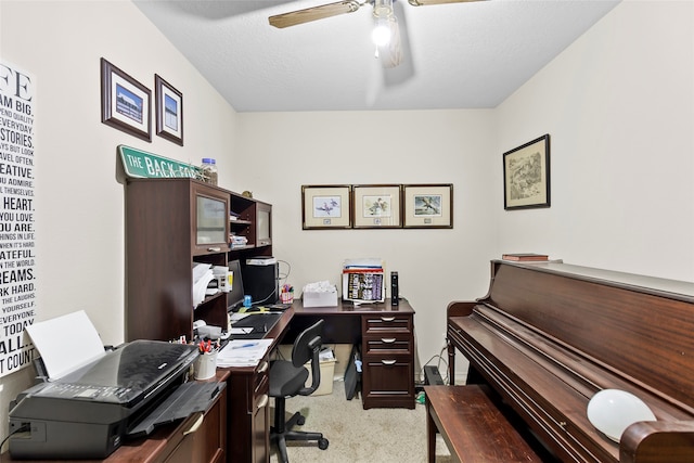 home office featuring ceiling fan, a textured ceiling, and light carpet