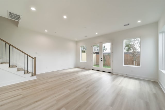 unfurnished living room featuring french doors and light hardwood / wood-style floors