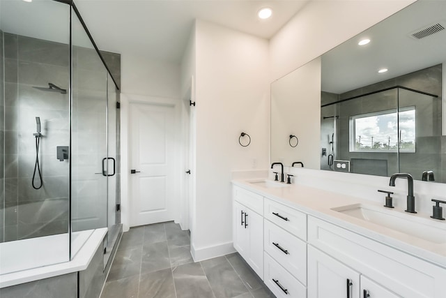 bathroom with vanity and a shower with door