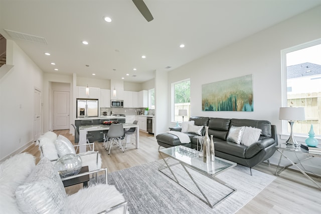 living room featuring light wood-type flooring and ceiling fan