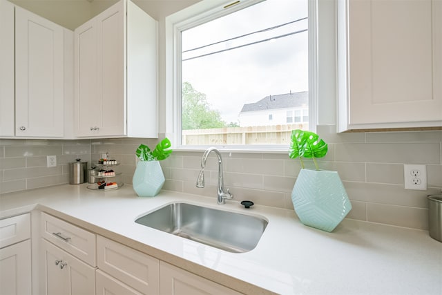 kitchen featuring white cabinetry, sink, and backsplash