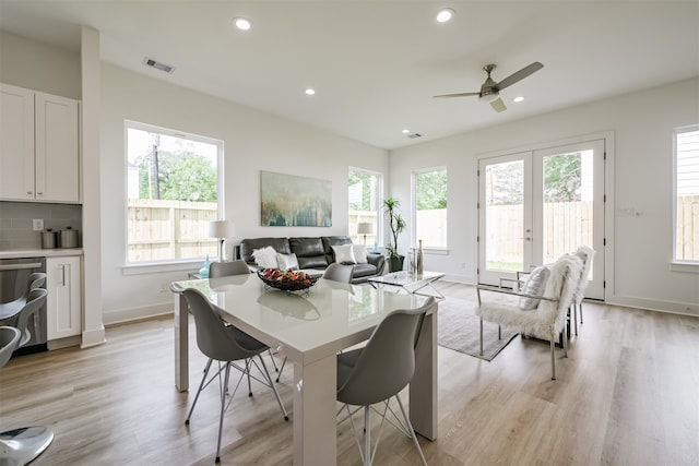 dining room featuring ceiling fan, a healthy amount of sunlight, light wood-type flooring, and french doors